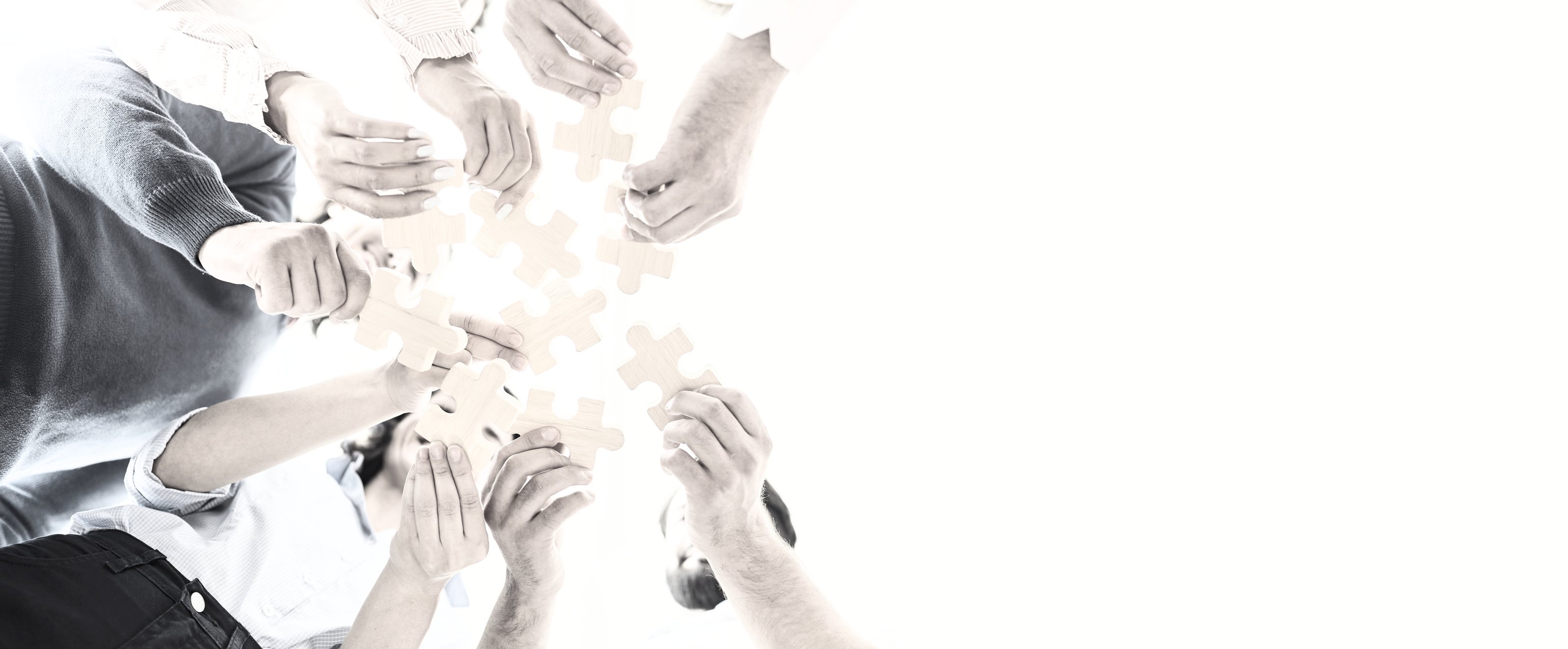 Happy Company Employees Joining Parts of Jigsaw Puzzle during Work Meeting or Team Building Activity